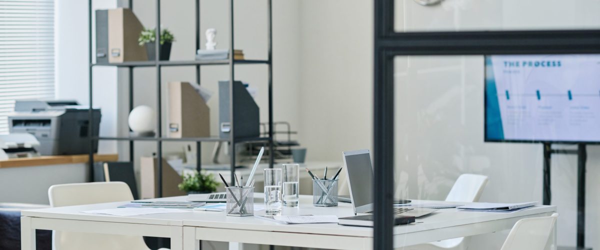Horizontal image of modern board room with table for meeting and screen for presentation