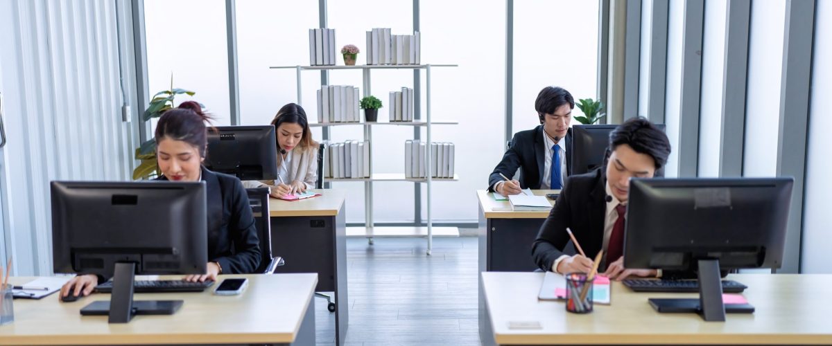 Business employee in formal suits working at table and discussing business strategy together