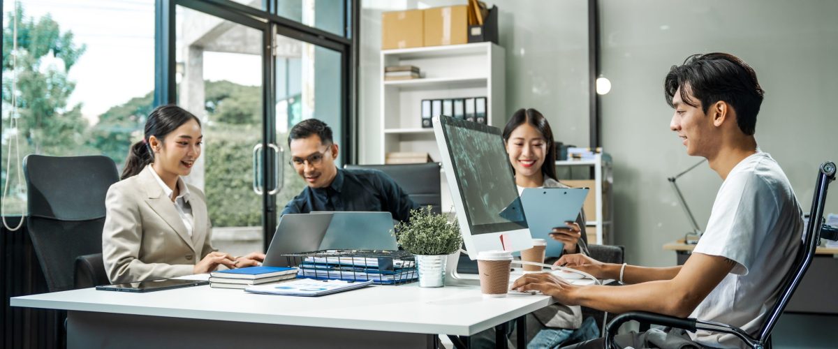 Asian colleagues meet at a desk, discussing business financial terms, investment strategies